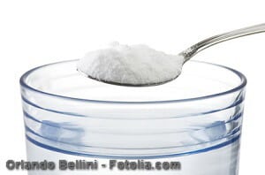 Spoon of baking soda over glass of water