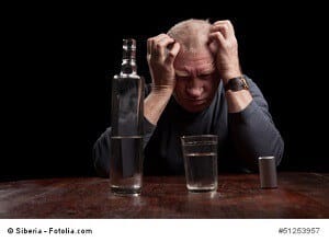 Dark portrait of a man holding his head in despair
