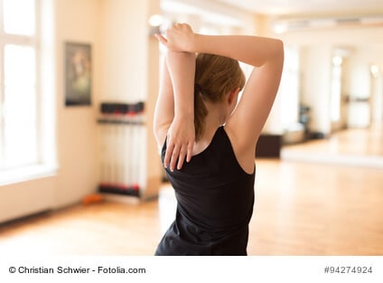 Junge Frau bei Sportübung im Fitnesscenter