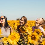 Fröhliche Frauen im Sonnenblumenfeld